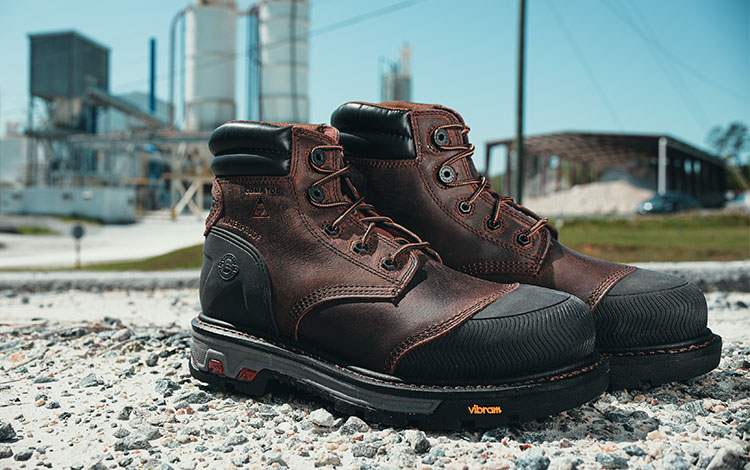 Pair of Justin Warhawk nano comp toe lace up boots in brown